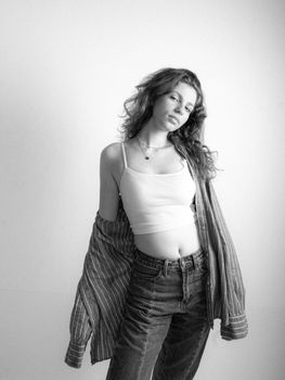 Monochrome image capturing a confident woman in casual fashion with flowing hair.