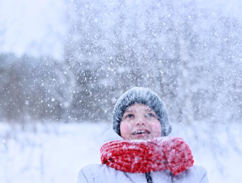 Snowfall over Smiling Boy in Scarf