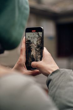A person photographing a cityscape with a smartphone, highlighting urban exploration.