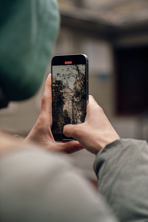 Free A person photographing a cityscape with a smartphone, highlighting urban exploration. Stock Photo