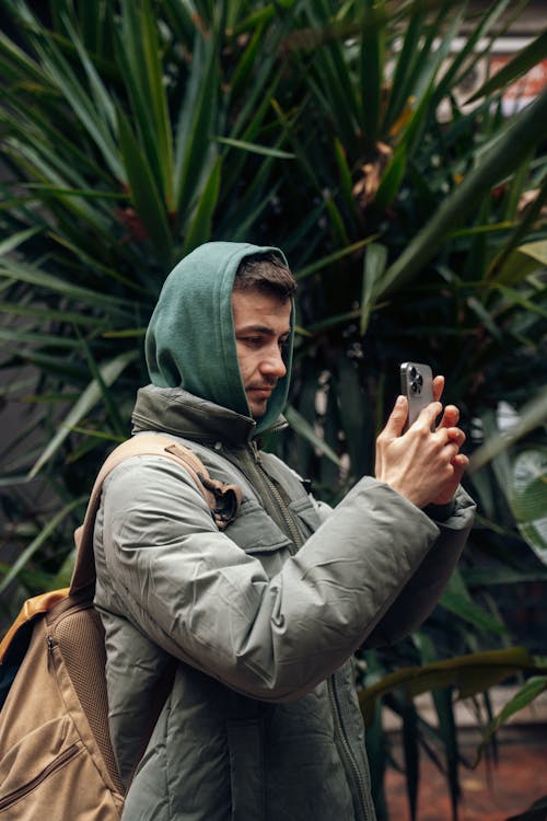 Základová fotografie zdarma na téma bunda, chytrý telefon, držení