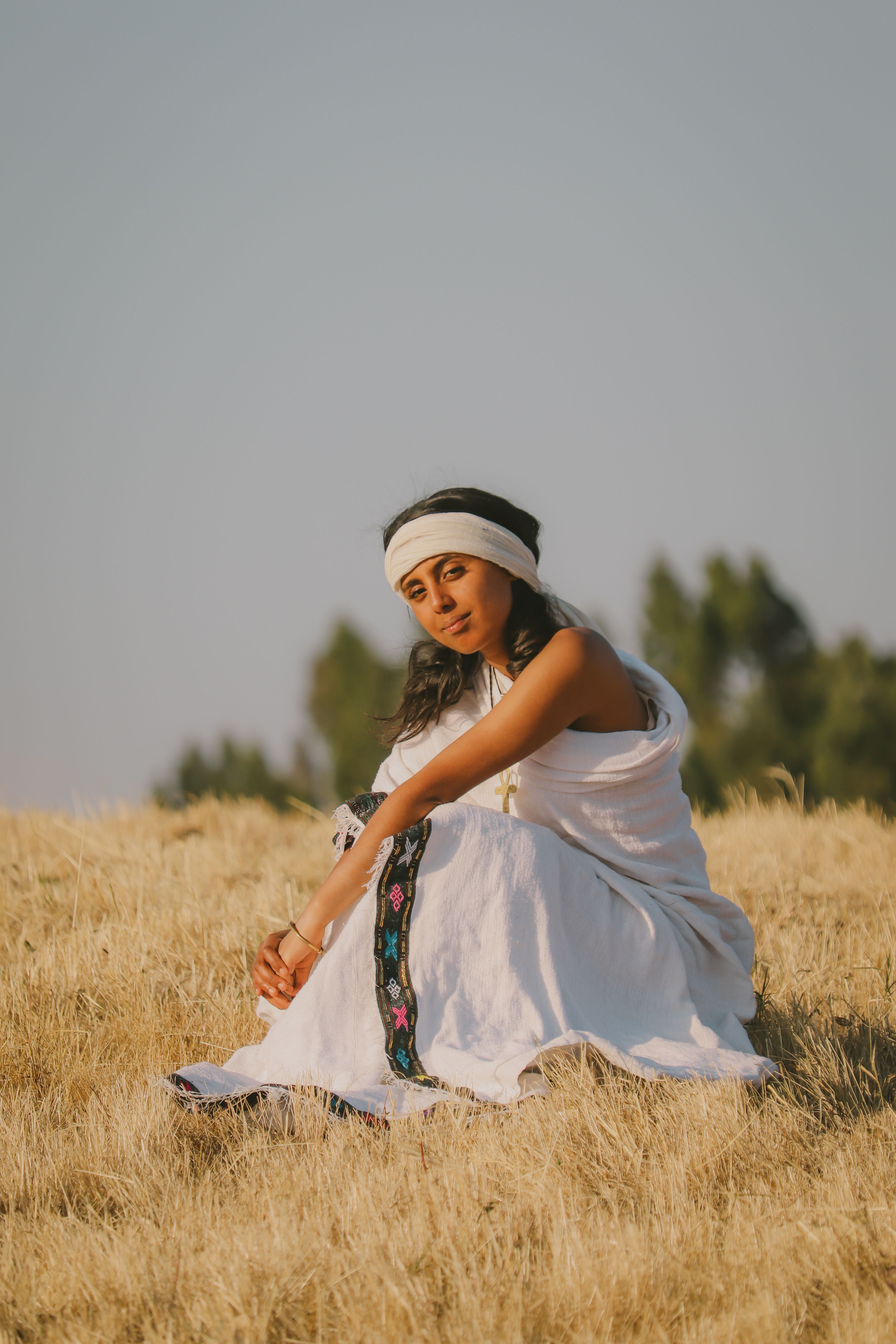 Young Woman in Traditional Clothing Sitting on the Grass · Free Stock Photo