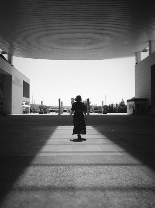 Woman in Dress Walking on Pavement