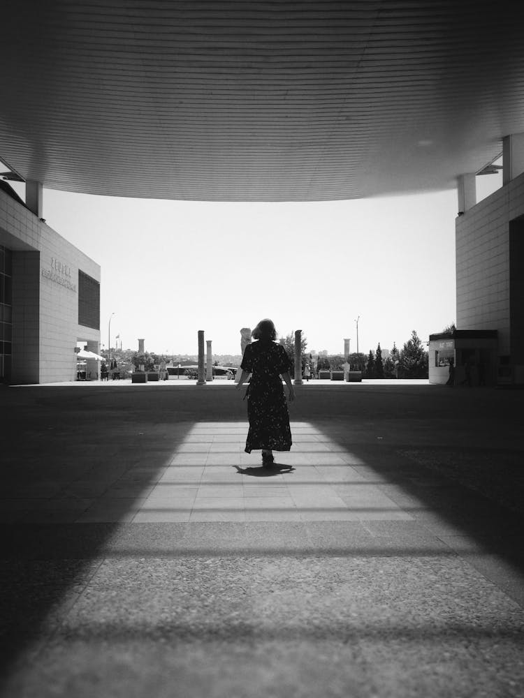 Woman In Dress Walking On Pavement