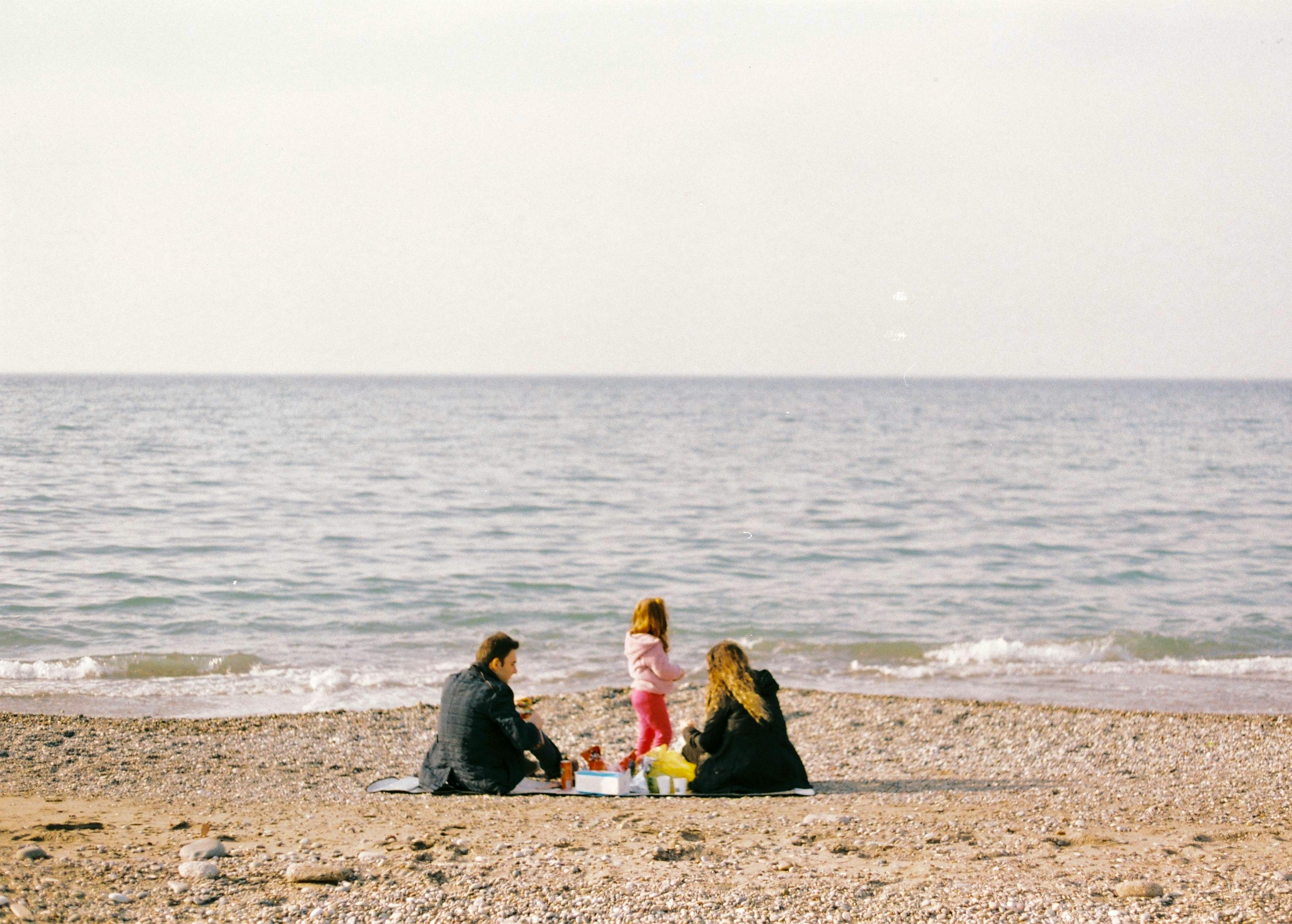 Estepona family beach with calm blue Mediterranean sea and parents with daughter