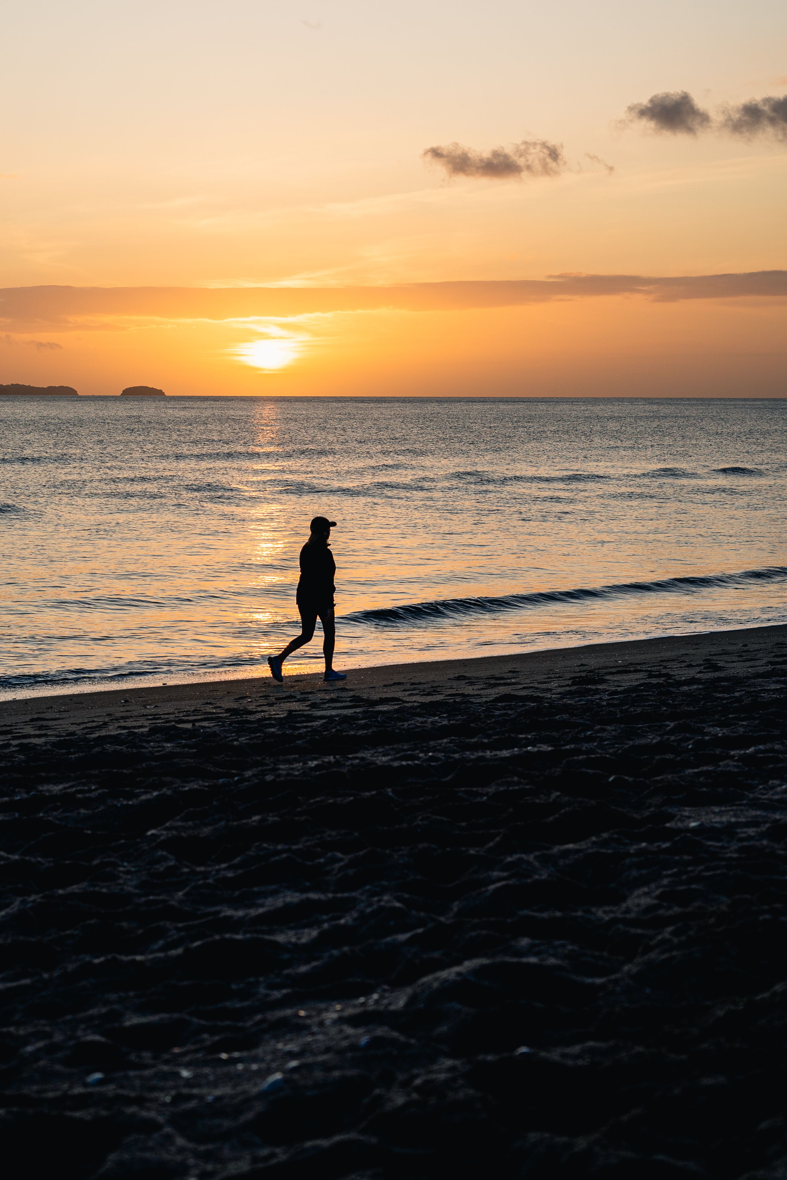 Silhouette of a Man Walking in the Sea at Sunset · Free Stock Photo