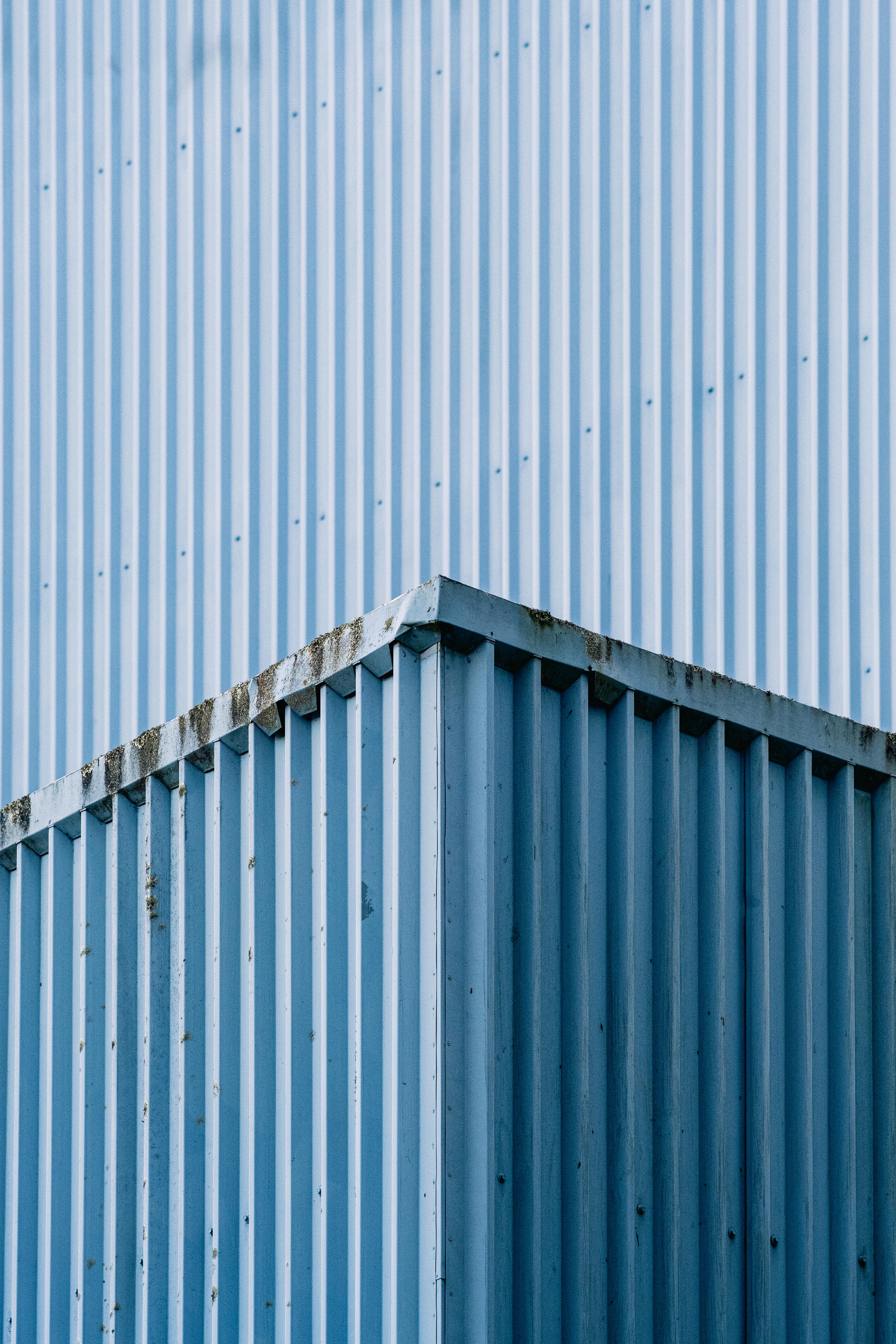 A blue metal building with a blue sky · Free Stock Photo
