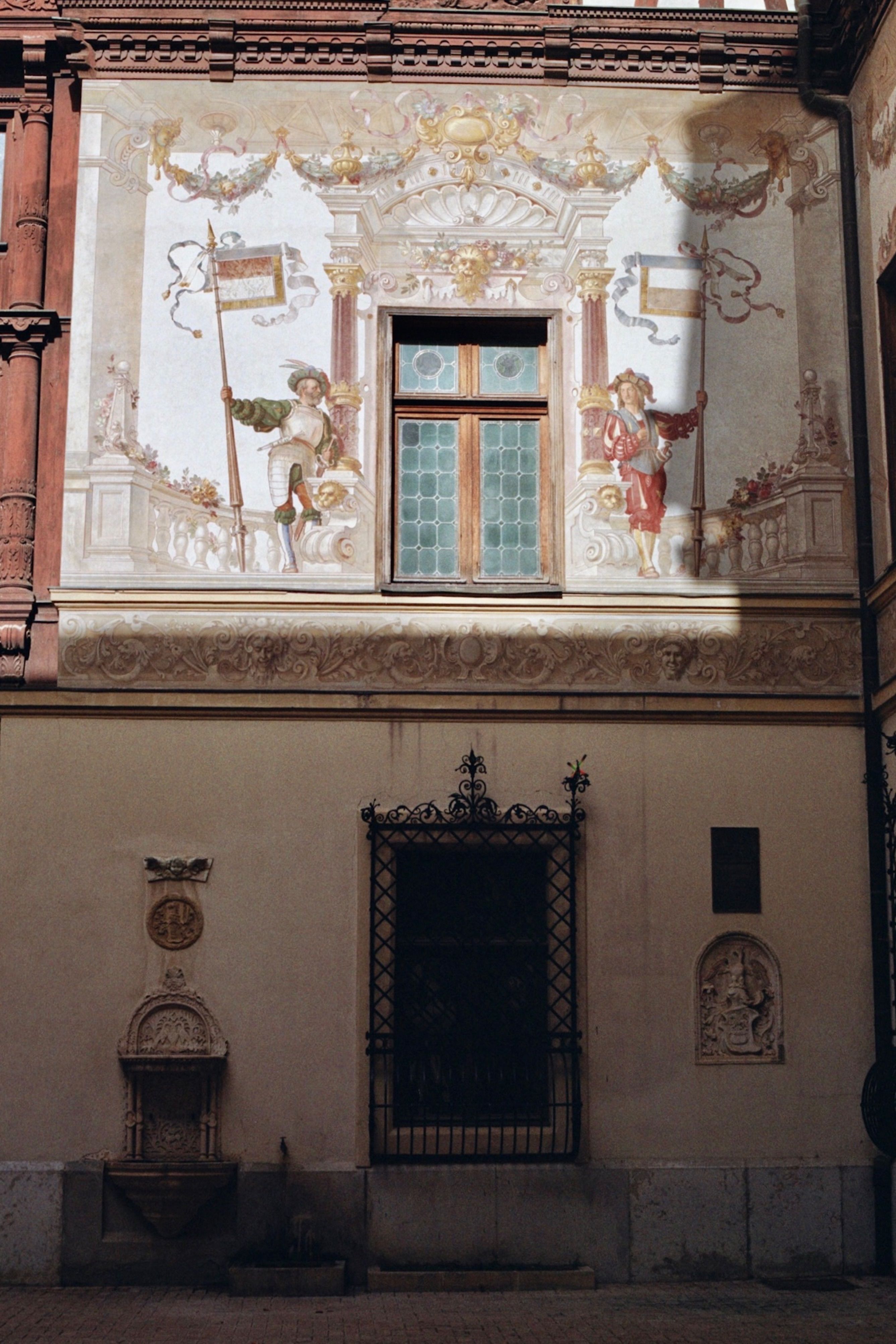 Beautifully adorned wall with intricate paintings in a Sinaia courtyard, Romania.