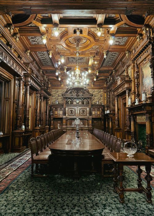 Free Ornate dining room inside Peles Castle, Sinaia, Romania, showcasing lavish woodwork and elegant decor. Stock Photo