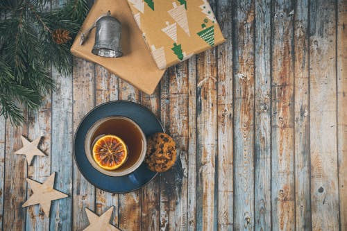 Cup of Tee with Lemon and Christmas Presents on a Wooden Table