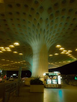 Striking night view of modern airport architecture with illuminated food stand in Mumbai.
