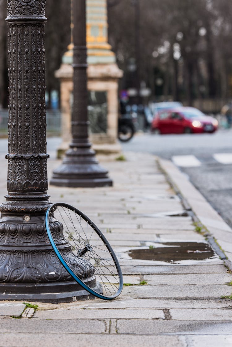 Bike Wheel By Post On Sidewalk