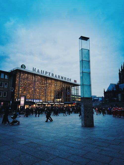 Free Crowds gather at Berlin Hauptbahnhof during a vivid twilight evening. Stock Photo