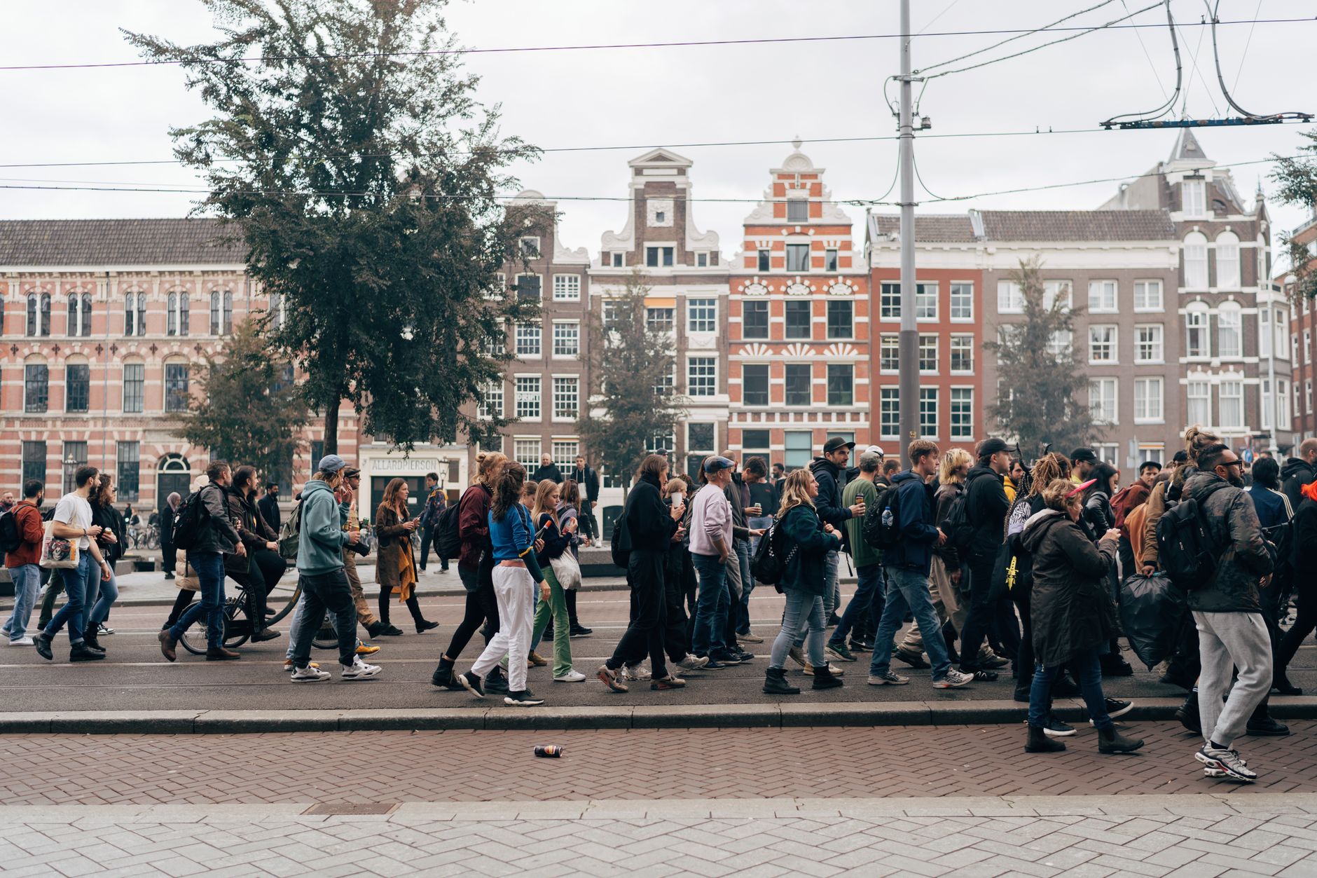 Amsterdam'da kalabalık bir sokak ve kanal kenarındaki evler