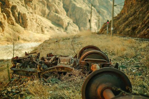 A train track with a broken wheel and a mountain in the background