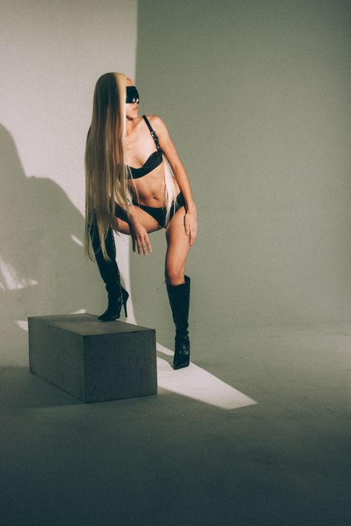 Free Stylish studio shot of a fashionable model in black lingerie and over-the-knee boots. Stock Photo