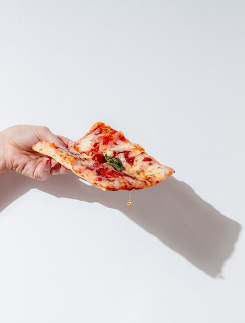 Woman Hand Holding Pizza Slice