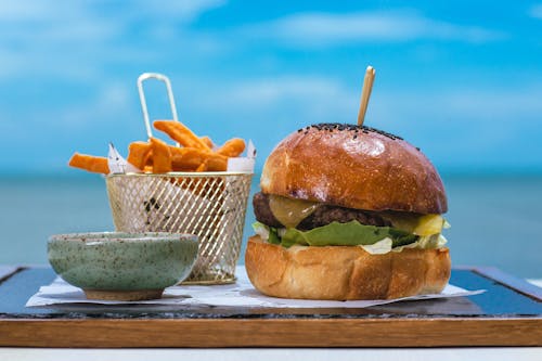 Free Photo of Fast Food on a Table, and a Blue Sea in Background Stock Photo