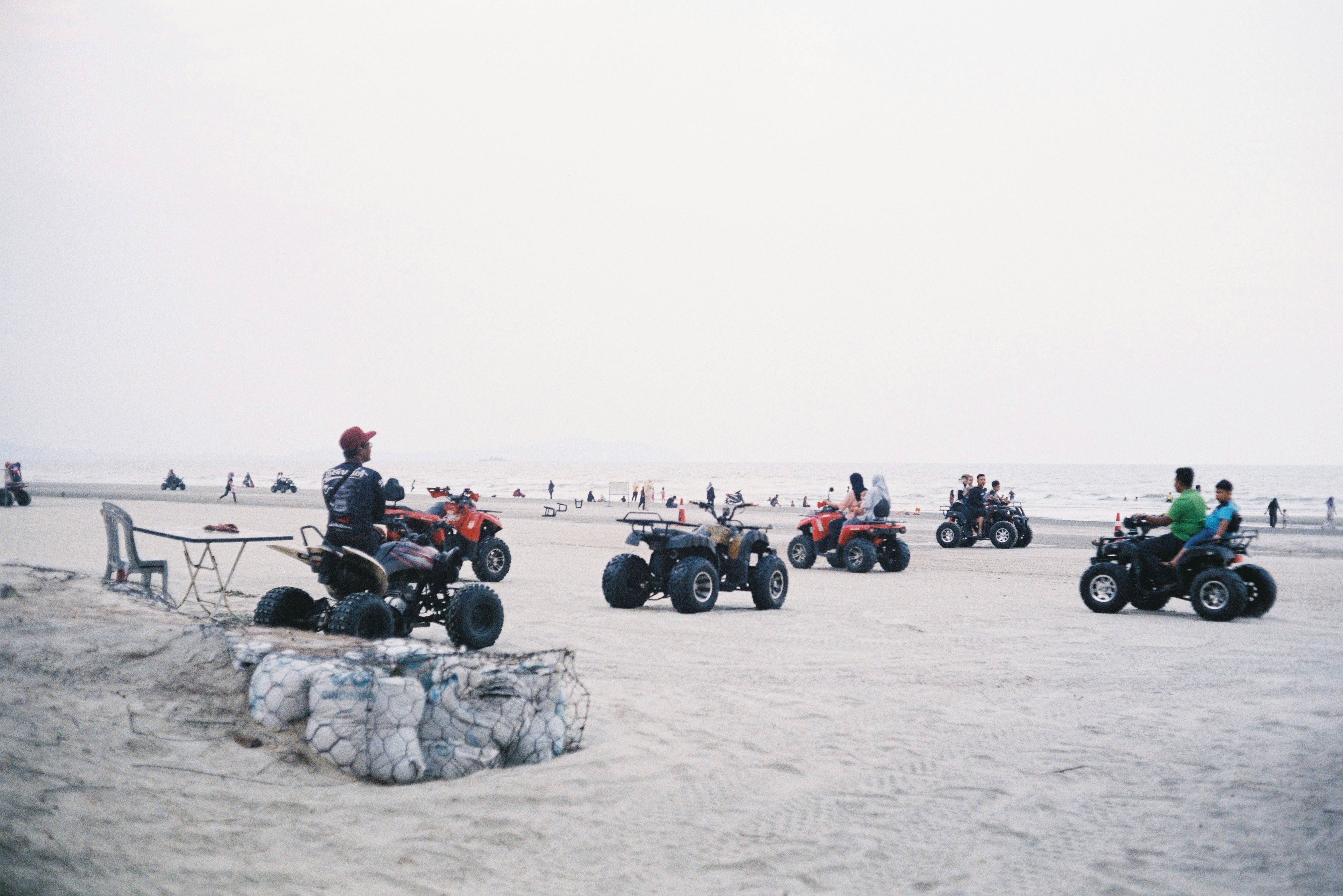 People enjoying an ATV ride on the sandy shores of Balok Beach, Pahang, Malaysia.