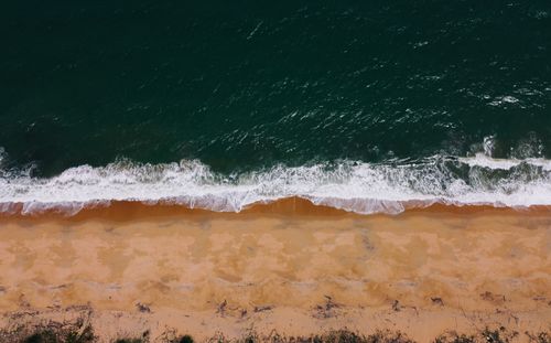 Free A stunning aerial view capturing the vibrant waves meeting the sandy beach in Kuantan, Malaysia. Stock Photo