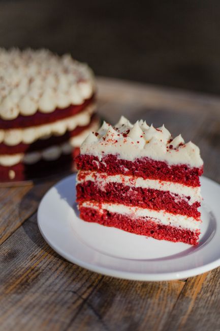 Close-up of a red velvet cake slice with creamy frosting, perfect for dessert lovers.