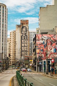 Vibrant city street view featuring colorful murals and urban buildings under a bright sky.