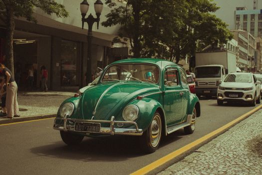 Classic green vintage car on an urban city street with old charm.
