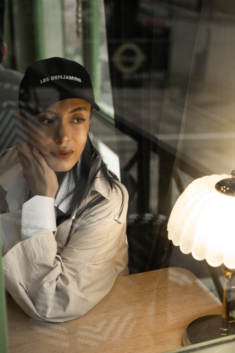 Woman Sitting In A Restaurant Behind A Window 