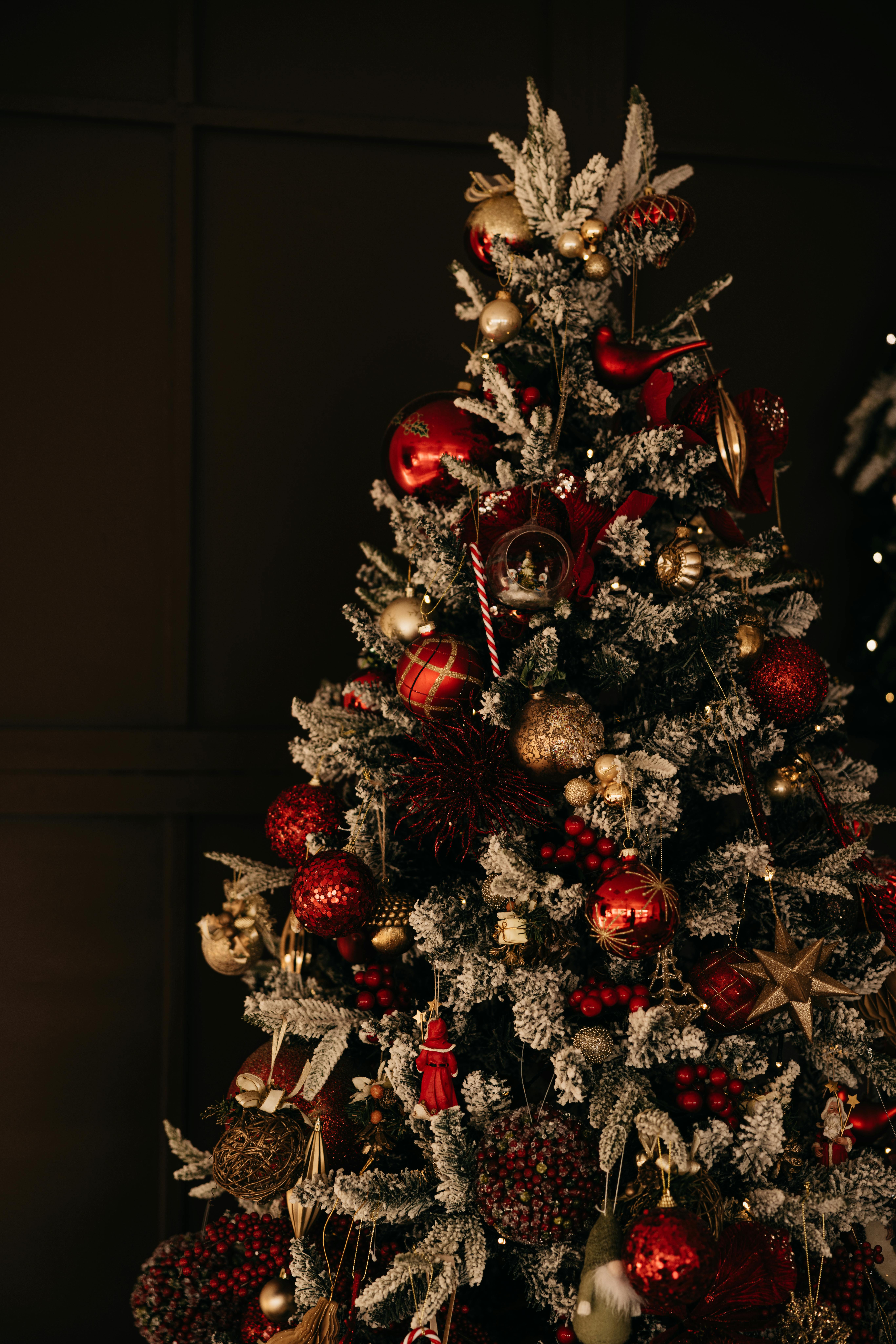 Festive Christmas tree adorned with red and gold ornaments, set in a cozy indoor atmosphere.