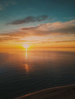 Captivating sunset over the tranquil sea at Mil Palmeras, Spain, with warm hues reflecting on the water.
