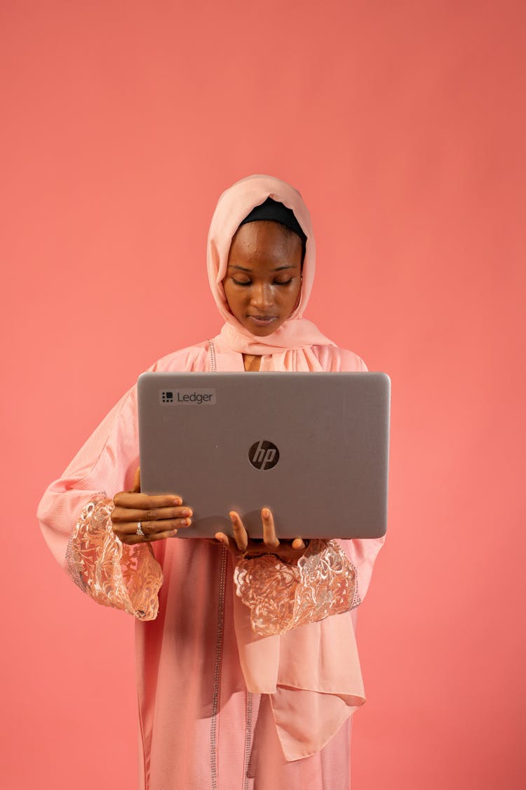 Studio Shot Of A Young Woman In Traditional Clothing Holding A Laptop