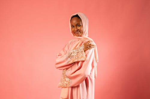 Studio Shot of a Young Woman in Traditional Clothing Posing on Pink Background 