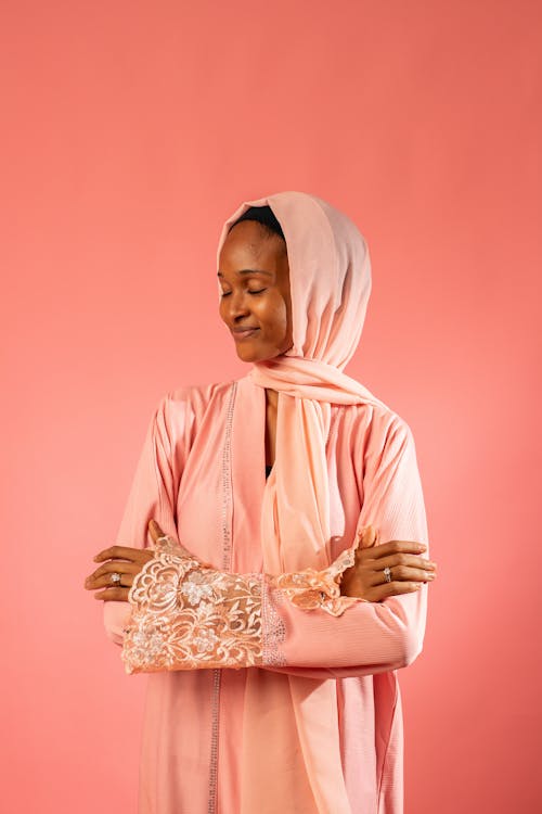 Studio Shot of a Young Woman in Traditional Clothing Posing on Pink Background 