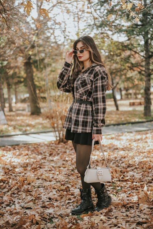 Woman in Sunglasses and with Bag in Park in Autumn
