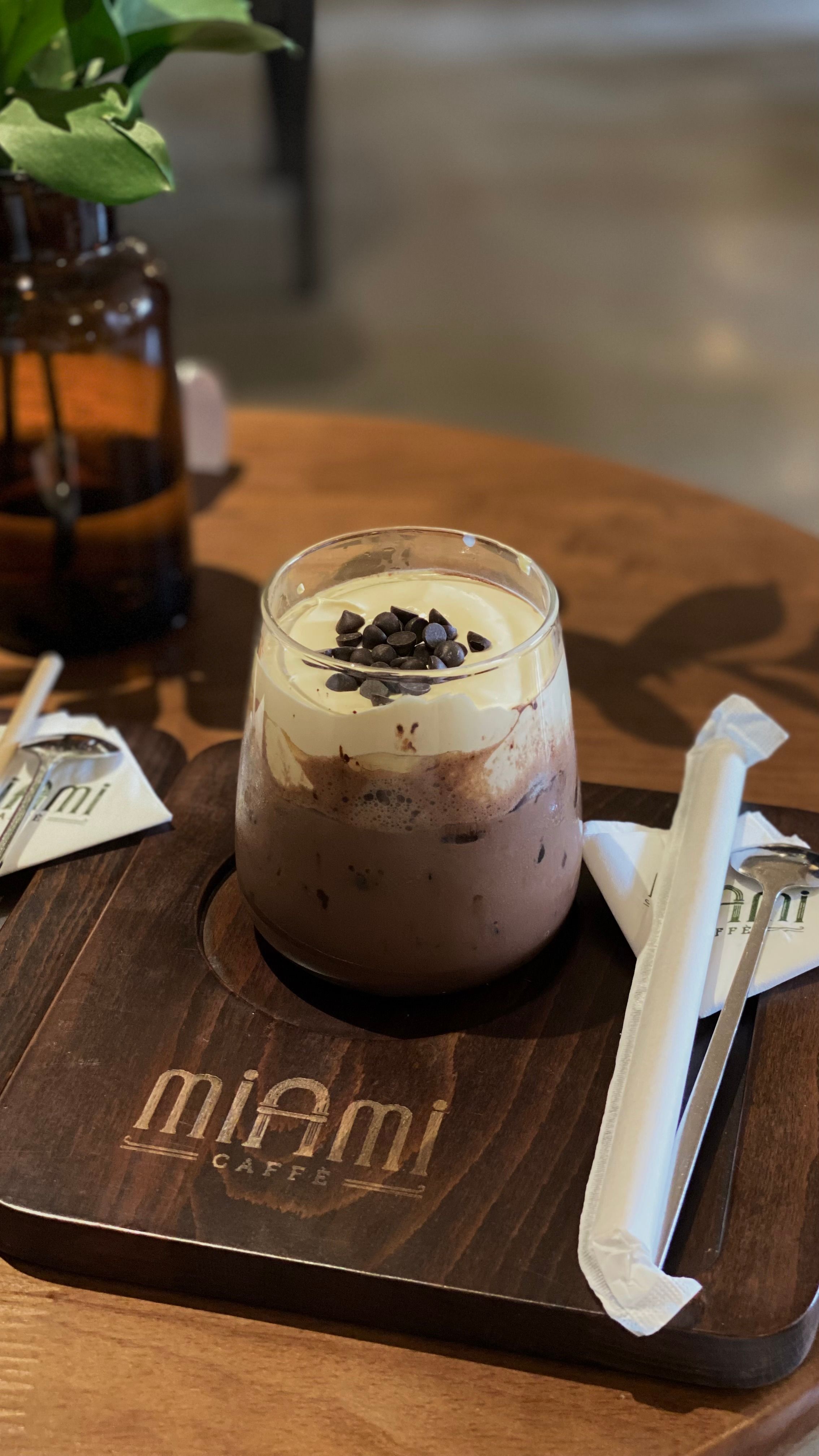 Close-up of a creamy iced coffee topped with chocolate chips at Miami Café.