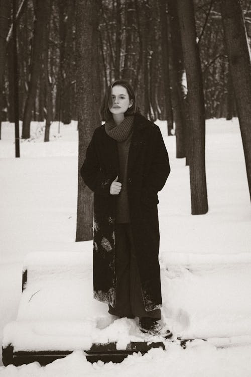 Woman Standing Between Trees on Winter Day