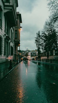 Urban city street view on a rainy day with reflections of lights. Captures the essence of urban travel.