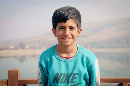 Young Boy Posing in Front of a Mountain Landscape