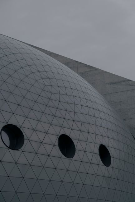 Modern architectural design featuring a futuristic dome with circular windows and geometric patterns.