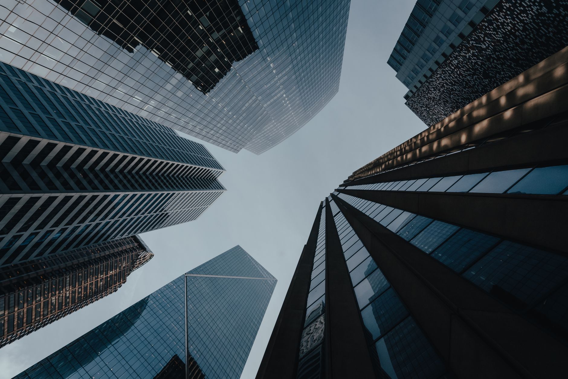 A dramatic upward view of modern skyscrapers creating a striking urban skyline.