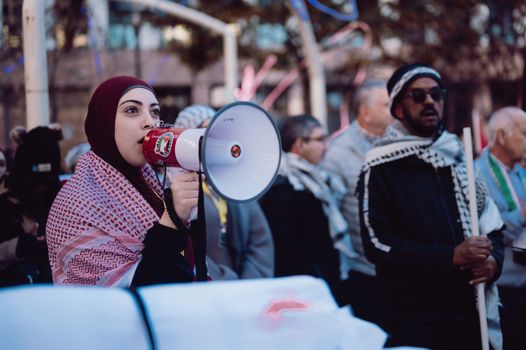 A woman with a megaphone in front of a crowd