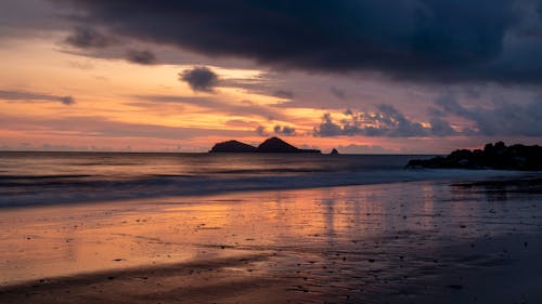 Scenic View of Sea and Beach under a Dramatic Sky at Sunset 