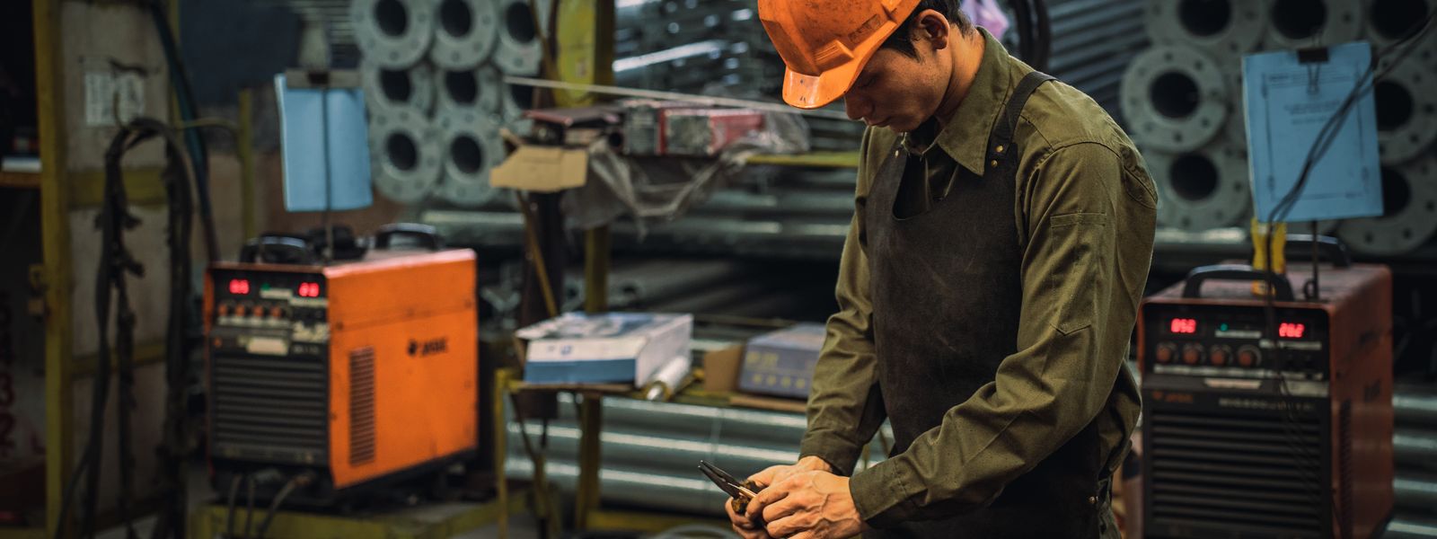 Factory worker wearing safety gear operating plant machinery