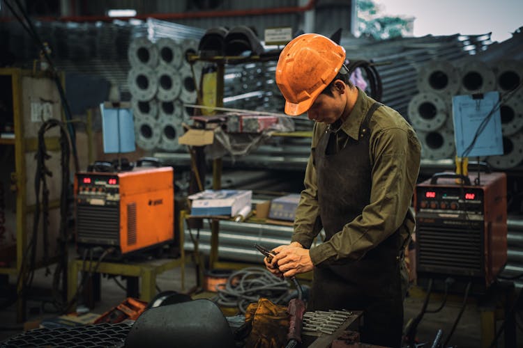 Man In Apron Working At Factory