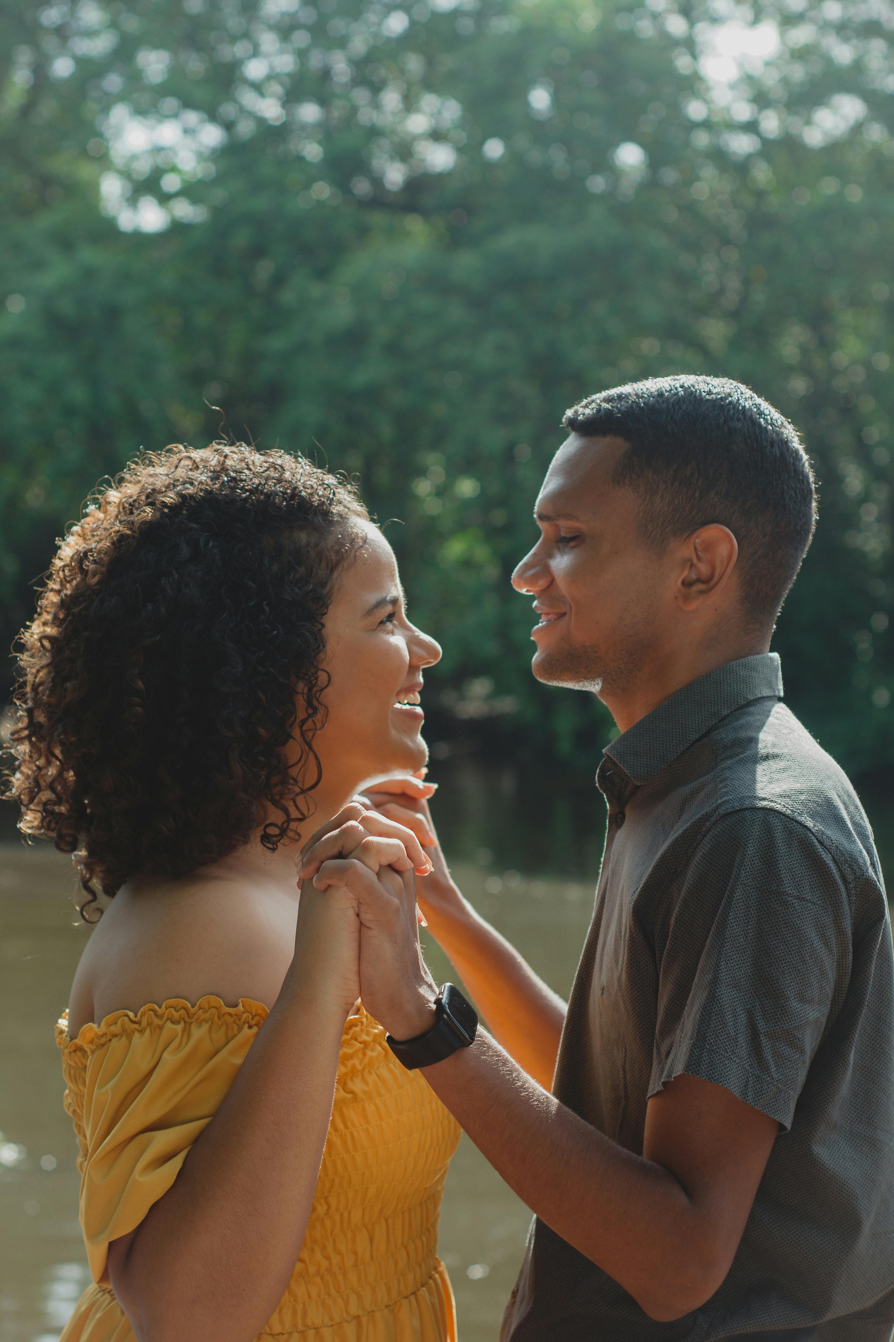 A happy couple shares a loving moment outdoors in a Brazilian park.
