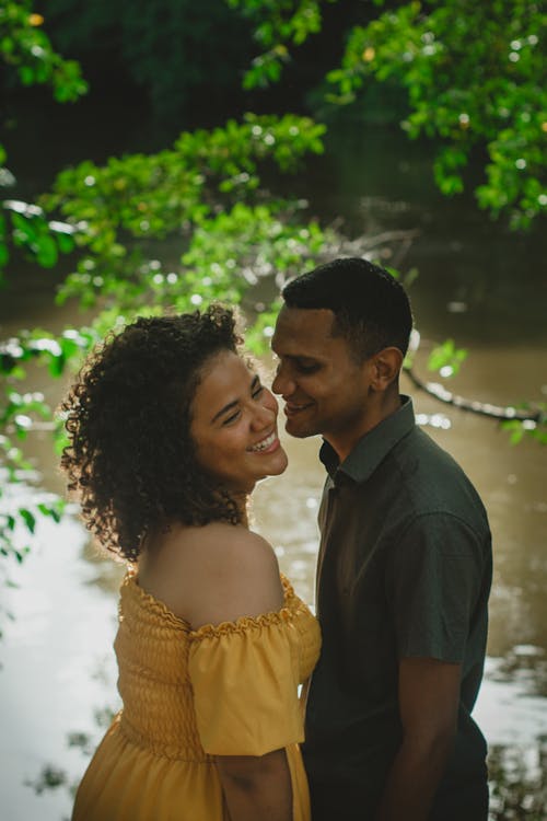 Young Couple Standing Together on a Riverbank