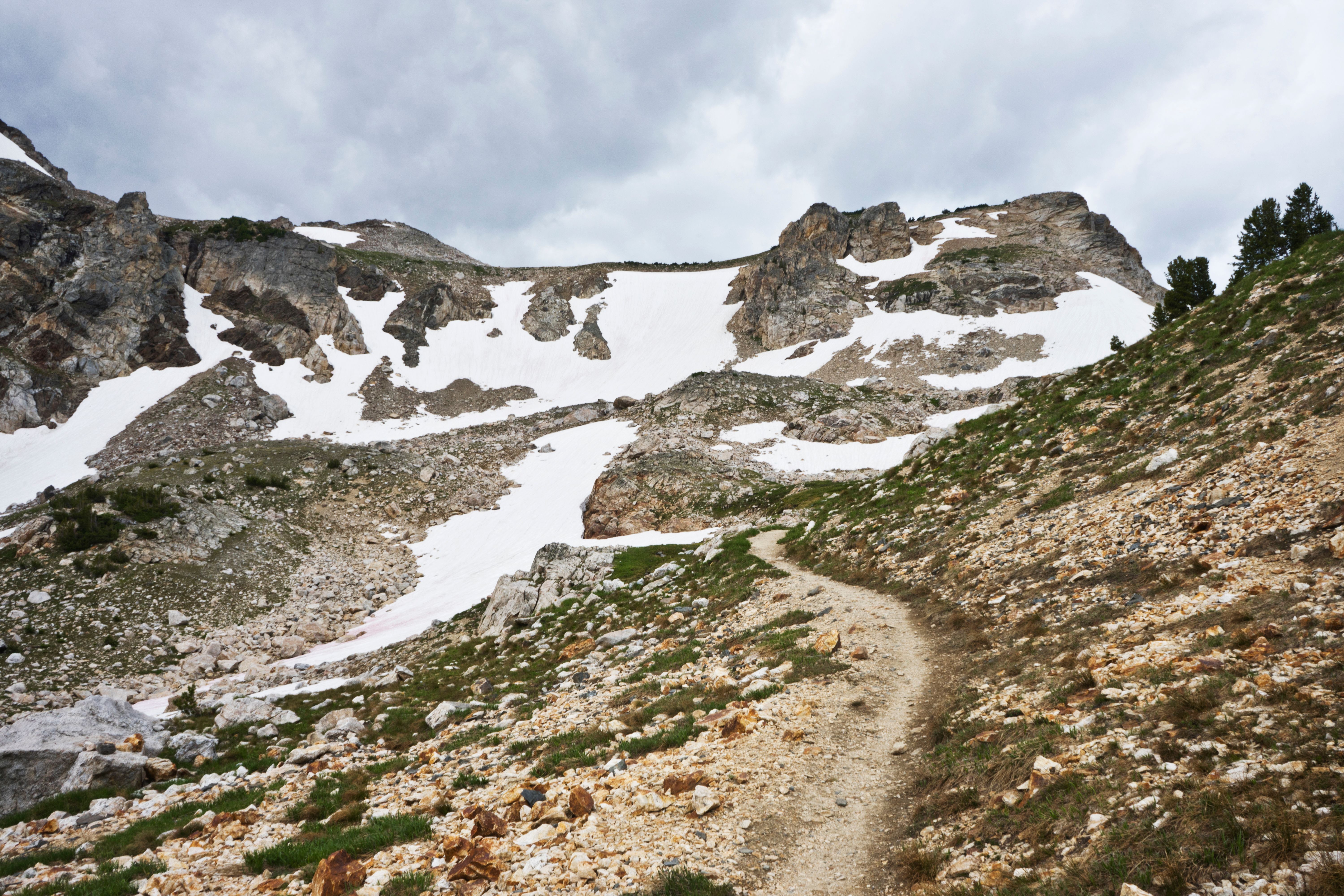 Winding mountain trail through rocky terrain with distant peaks