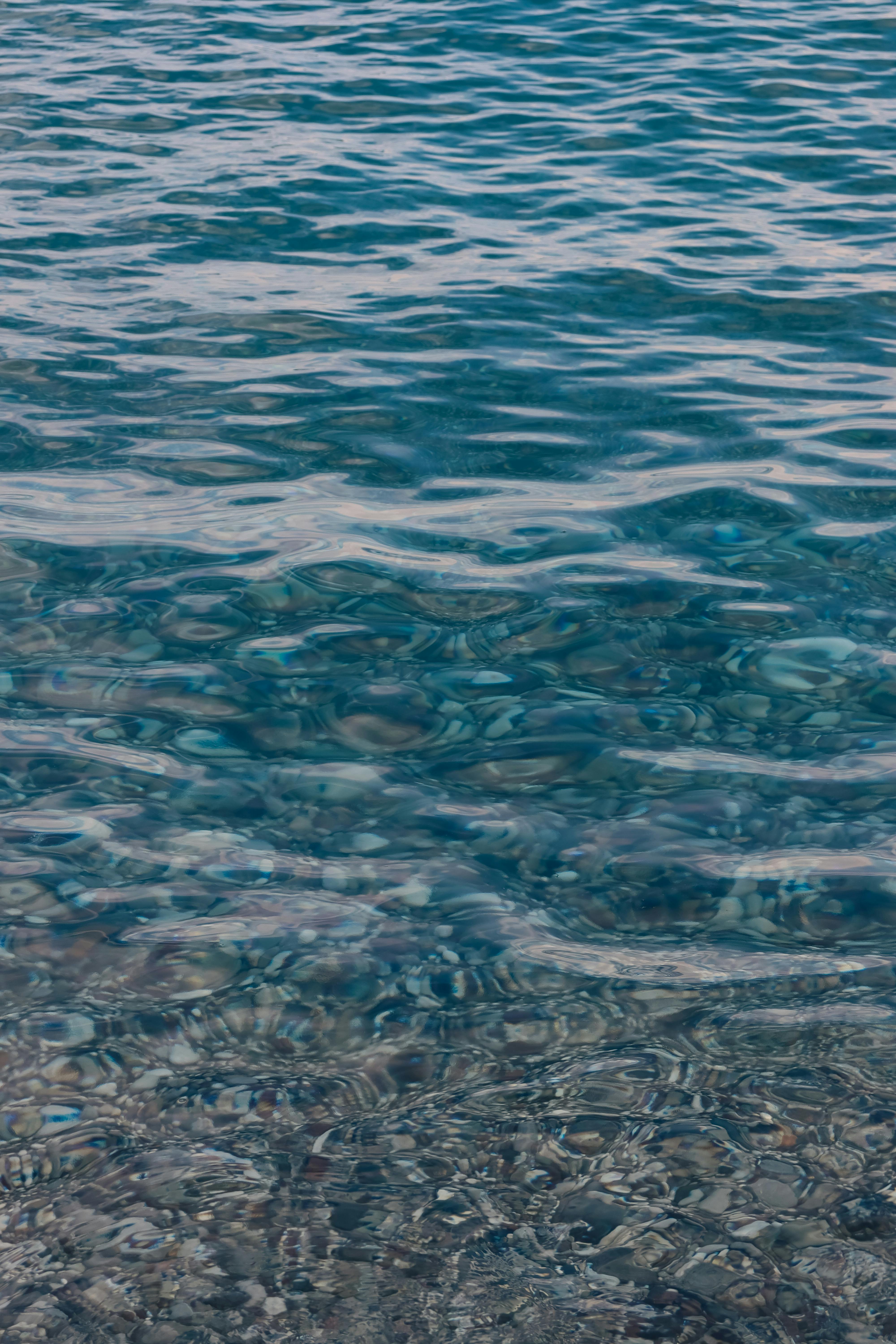 Peaceful ocean scene with gentle waves and visible seabed.