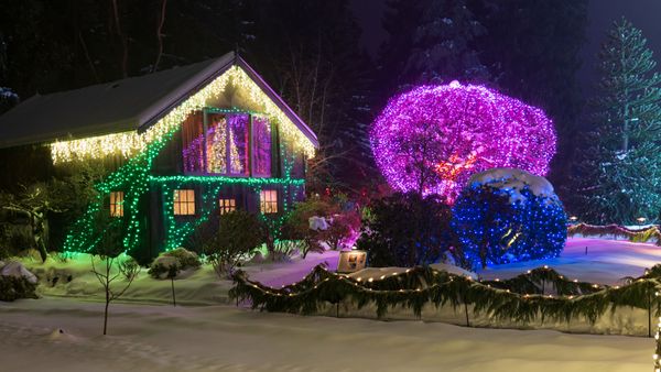 Home with festive Christmas light display in snow