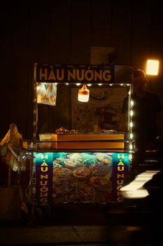 A vibrant street food stand illuminated at night showcasing Vietnamese cuisine.